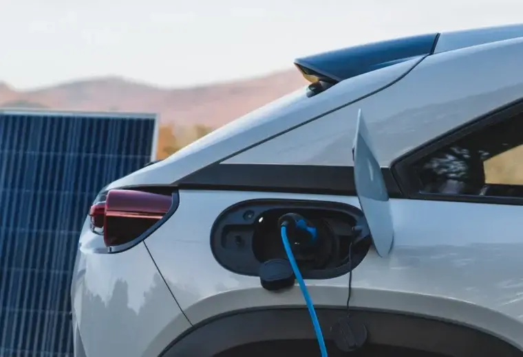 Electric car charging via rear port beside a solar panel
